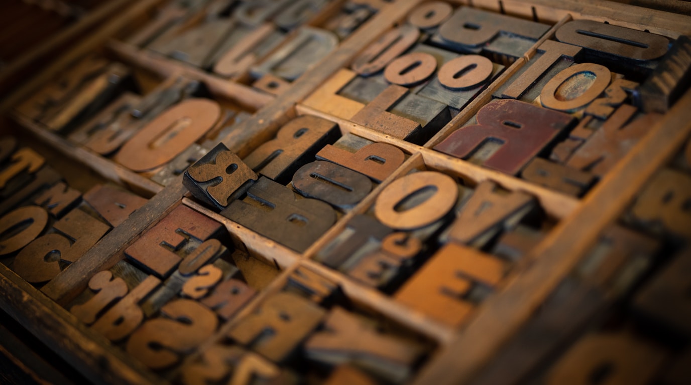 Close-up of a vintage letterpress typeset with scattered wooden letters